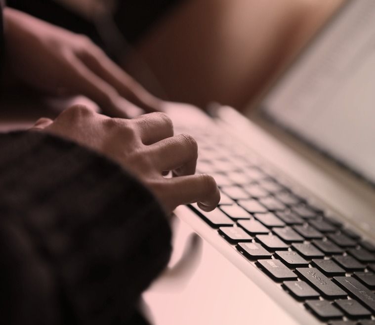 Young woman working on a gray laptop